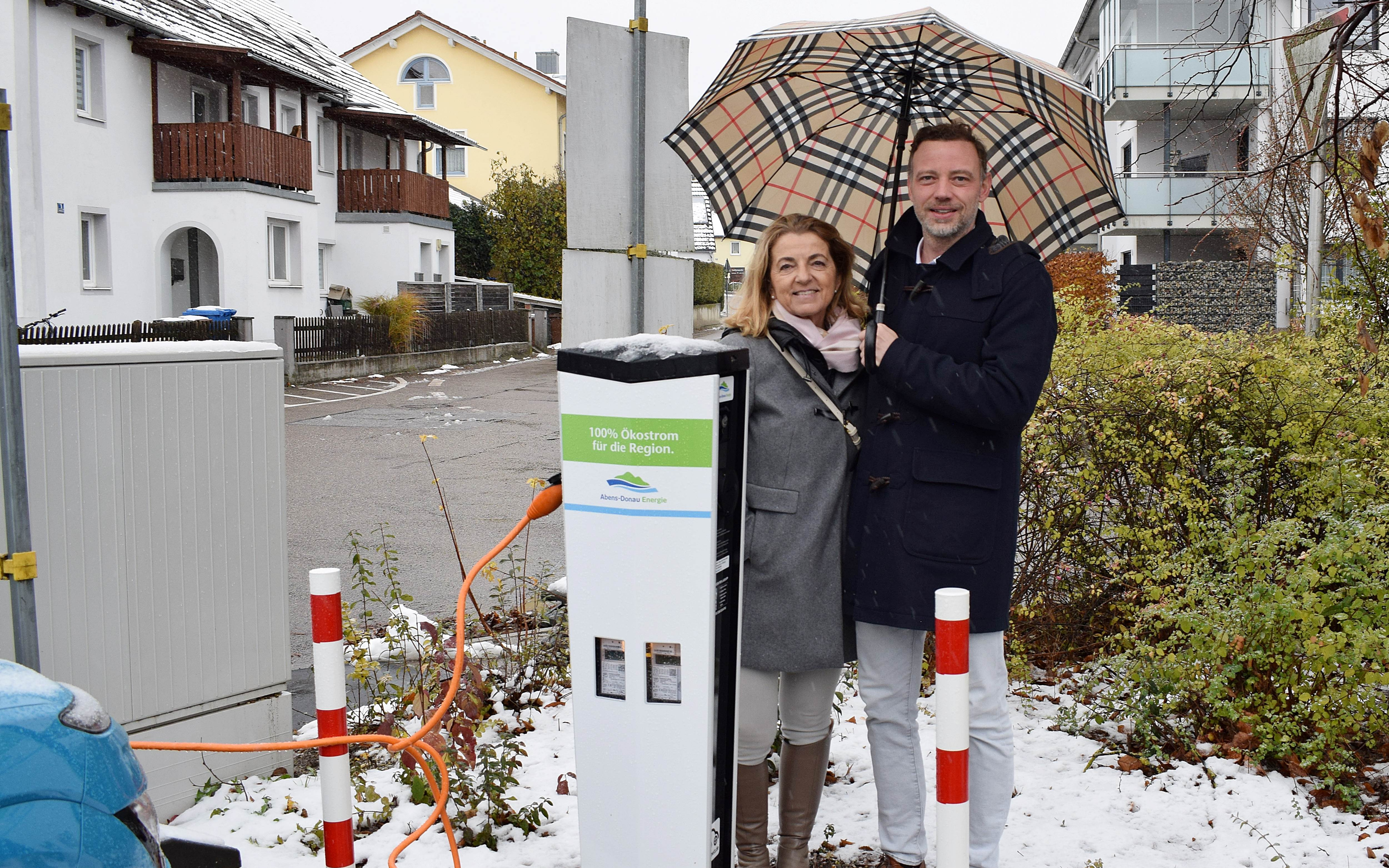 Zwei Personen neben einer Ladesäule der Abens-Donau Energie vor der Ilmtalklinik.