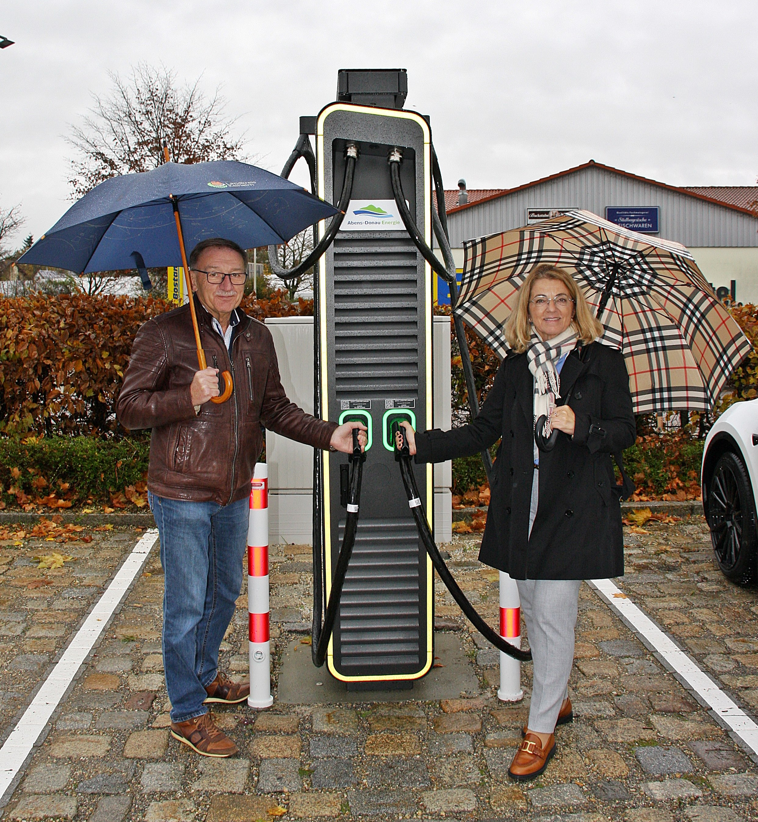 Zwei Personen weihen einen neuen Schnelllader der Abens-Donau Energie in Markt Siegenburg ein.