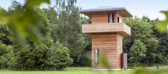 Ein Holzturm im Wald.