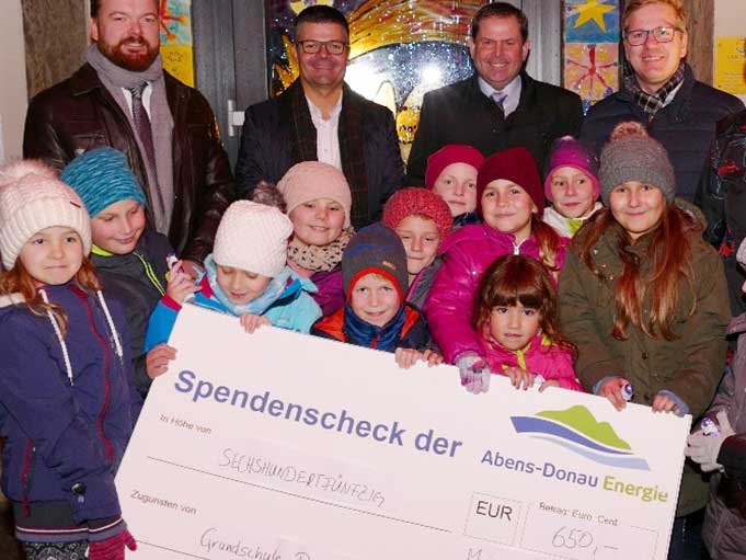 Vier Männer und 12 Kinder bei der Spendenscheckübergabe der Abens-Donau Energie an eine Grundschule.