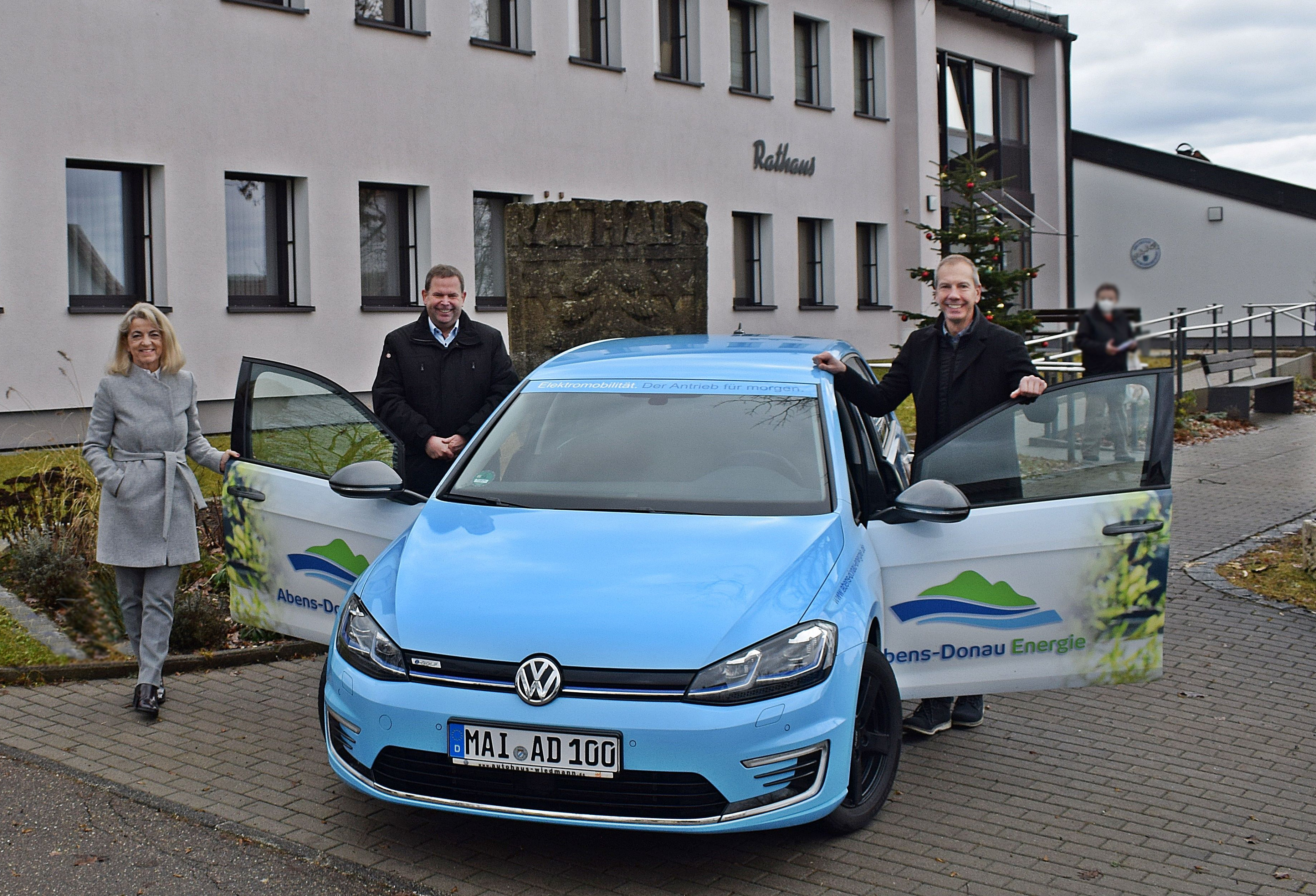 Drei Personen stehen um das E-Wanderauto der Abens-Donau Energie herum.